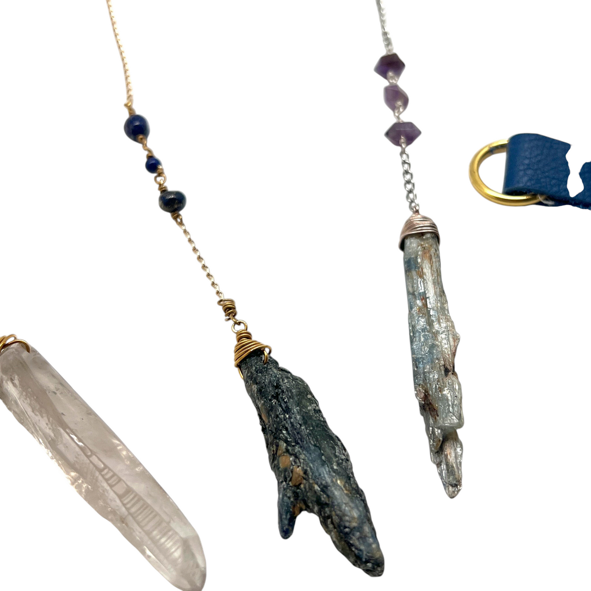 Ruby Feathers handcrafted crystal pendulums with raw smoky quartz, black tourmaline, and silver-toned metal chains.