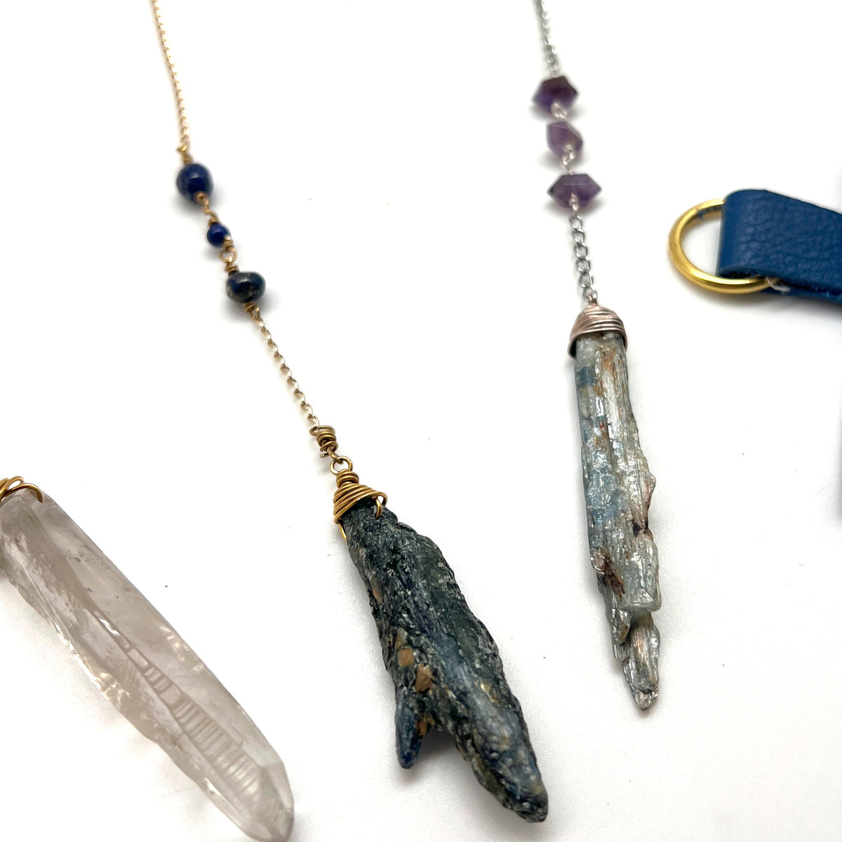 Ruby Feathers handcrafted crystal pendulums featuring raw blue kyanite, lapis lazuli, and brass wire wrapping.