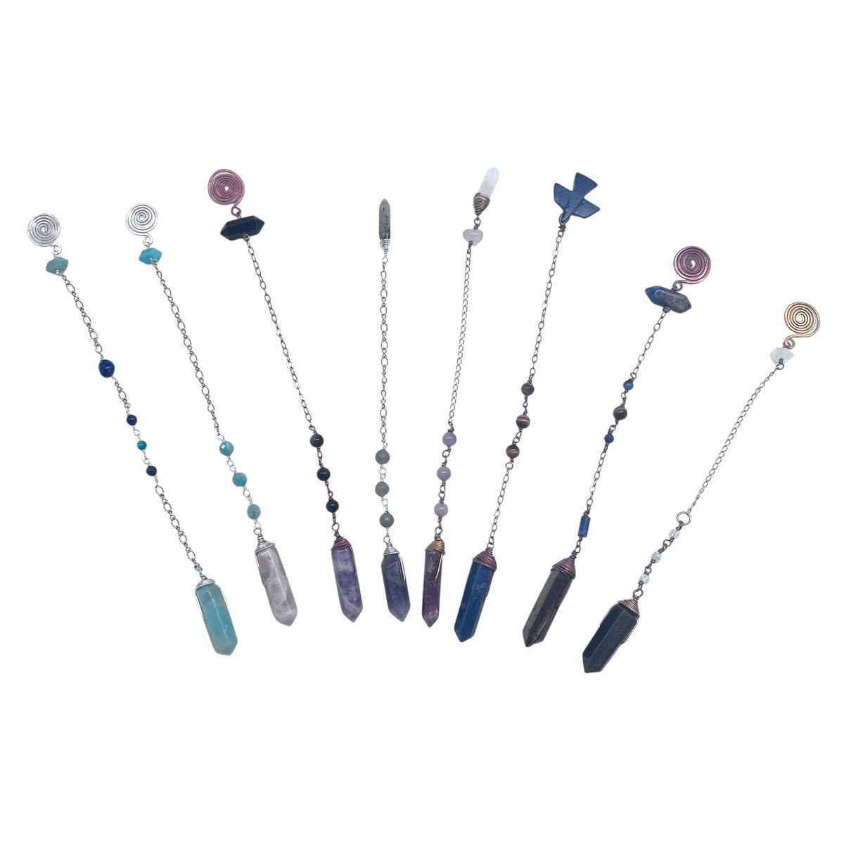 Ruby Feathers collection of handcrafted crystal pendulums with gemstone points, beaded chains, and silver spiral tops.