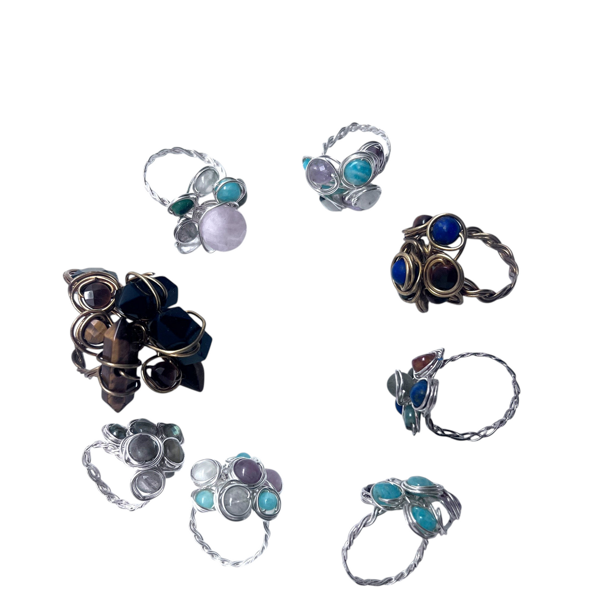 Ruby Feathers collection of handcrafted wire-wrapped crystal cluster rings with various gemstones on white background