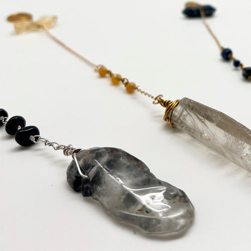Ruby Feathers handcrafted crystal pendulums featuring blue kyanite, amethyst, and steel elements for energy work.